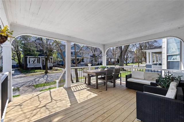 wooden deck with an outdoor hangout area, outdoor dining space, and a residential view