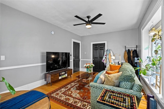 living area featuring ceiling fan, wood finished floors, and baseboards