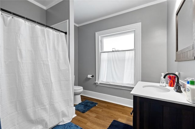 full bathroom featuring baseboards, toilet, ornamental molding, wood finished floors, and vanity