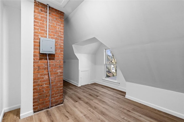 additional living space featuring vaulted ceiling, wood finished floors, and baseboards