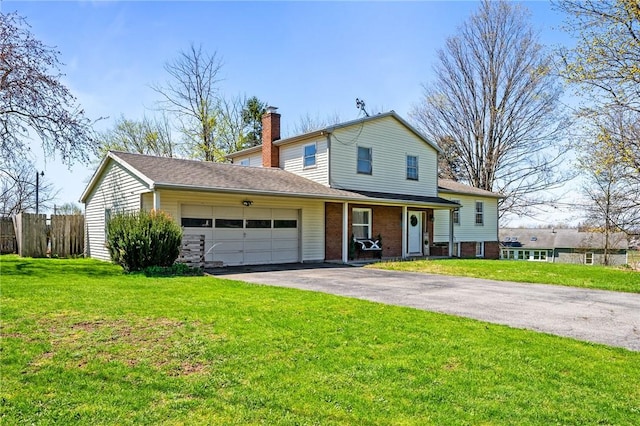 tri-level home with driveway, a chimney, a front yard, an attached garage, and fence
