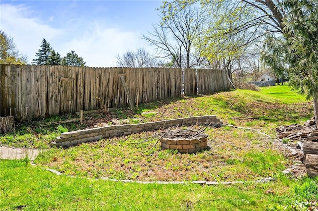 view of yard featuring a fire pit and fence