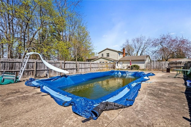 view of pool featuring a water slide, a patio, a fenced backyard, and a fenced in pool