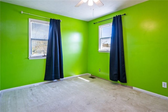 spare room featuring baseboards, a ceiling fan, and carpet flooring