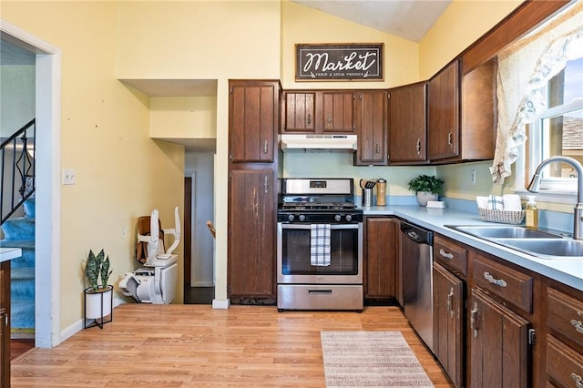 kitchen featuring a sink, light wood-style flooring, stainless steel appliances, and under cabinet range hood