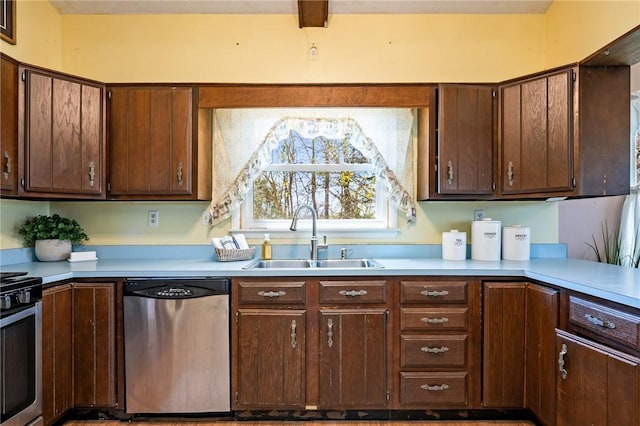 kitchen with a sink, stainless steel appliances, and light countertops
