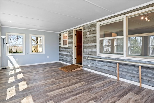 interior space featuring crown molding, wood finished floors, and baseboards