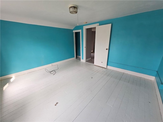 empty room featuring wood finished floors and baseboards