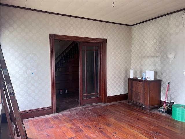 empty room featuring ornamental molding and hardwood / wood-style floors