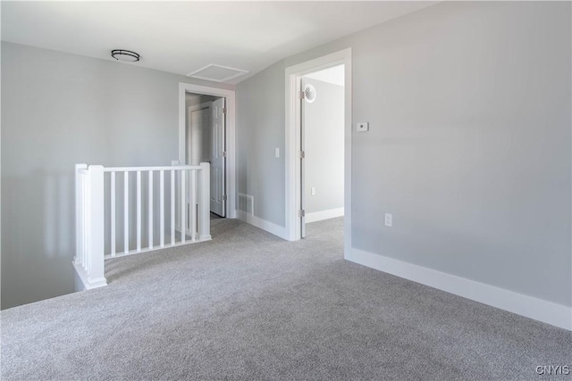 spare room featuring attic access, visible vents, carpet floors, and baseboards
