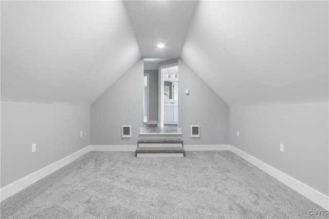 bonus room with visible vents, carpet, and vaulted ceiling