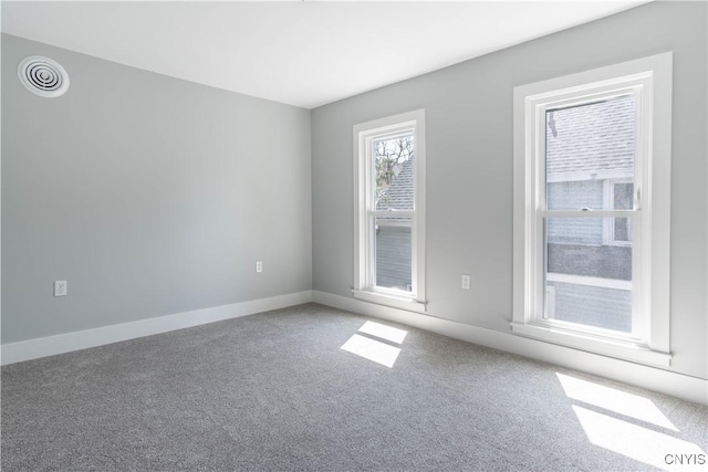 unfurnished room featuring baseboards, visible vents, and carpet