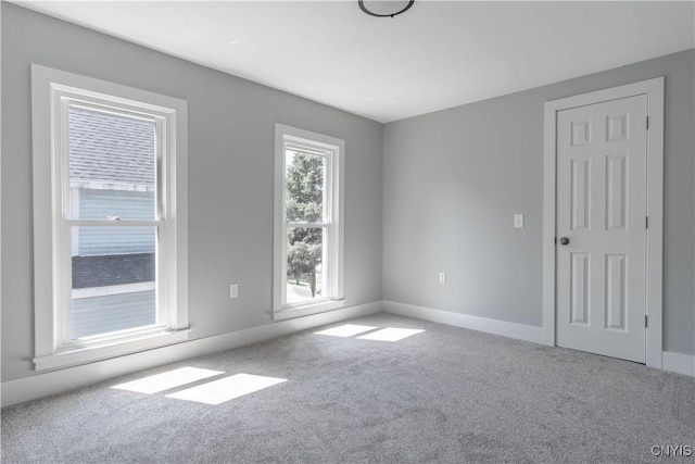 unfurnished room with carpet and baseboards
