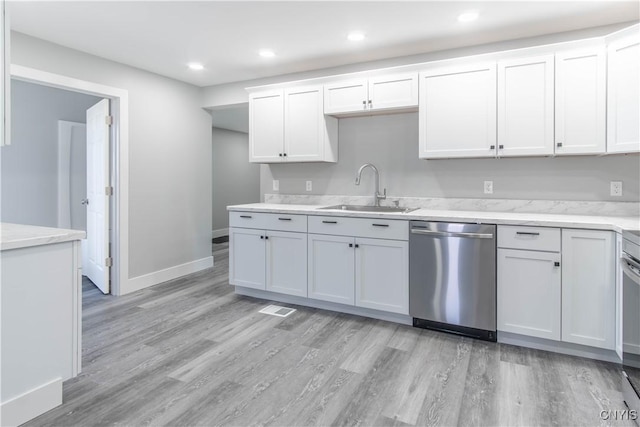 kitchen with dishwasher, light wood-style flooring, and a sink