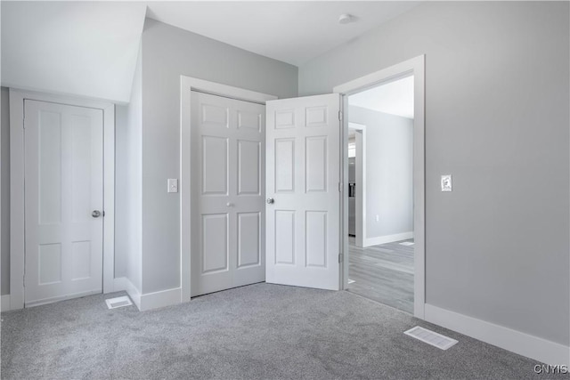 unfurnished bedroom featuring baseboards, visible vents, a closet, and carpet