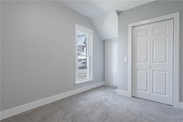 bonus room with baseboards, lofted ceiling, and carpet flooring