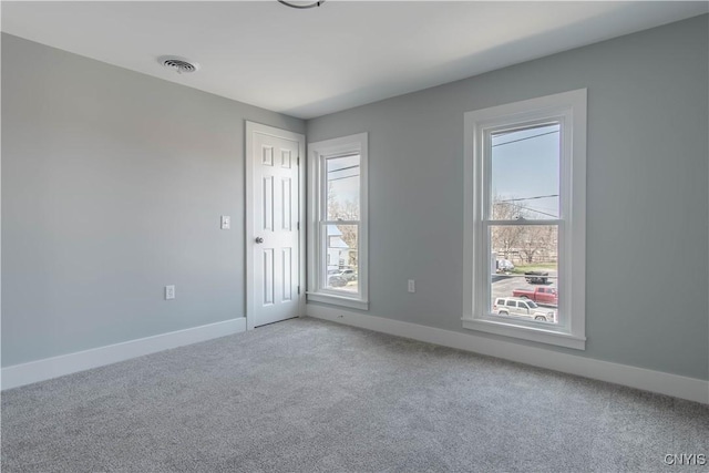 carpeted spare room with baseboards and visible vents