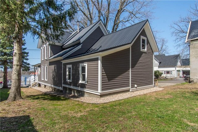 view of side of property with metal roof and a yard