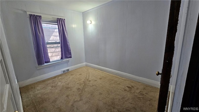 spare room with baseboards, visible vents, and carpet