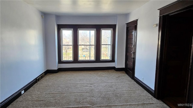 spare room with baseboards and carpet floors