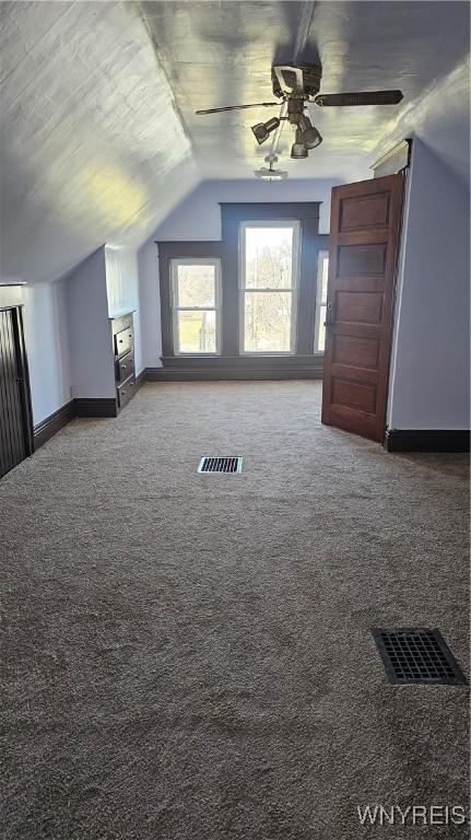 bonus room with carpet flooring, visible vents, ceiling fan, and vaulted ceiling