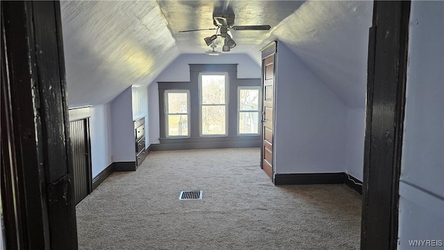 bonus room with carpet flooring, baseboards, visible vents, a ceiling fan, and lofted ceiling