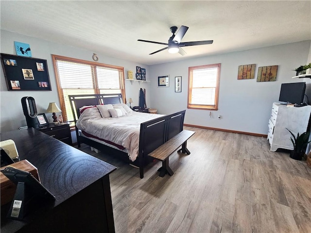 bedroom featuring wood finished floors, a ceiling fan, and baseboards