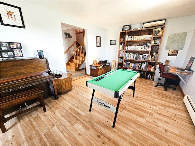 recreation room with a baseboard radiator, light wood-style floors, and billiards