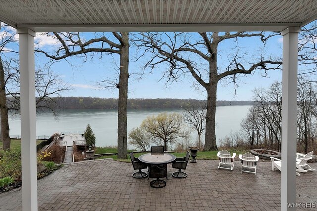view of patio with an outdoor fire pit and a water view