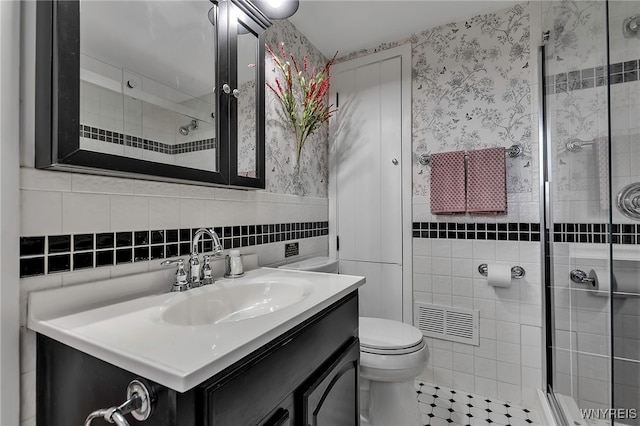 full bathroom featuring tile walls, visible vents, a shower stall, and vanity