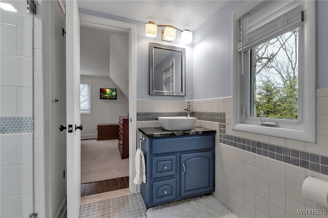 full bathroom with tile walls, tile patterned flooring, and vanity