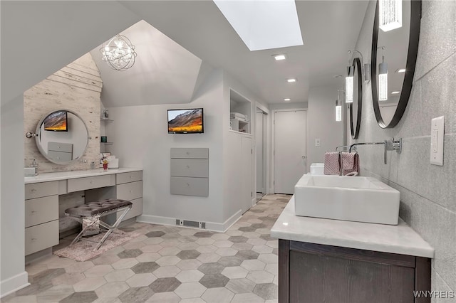 full bath with baseboards, a skylight, tile patterned floors, and vanity
