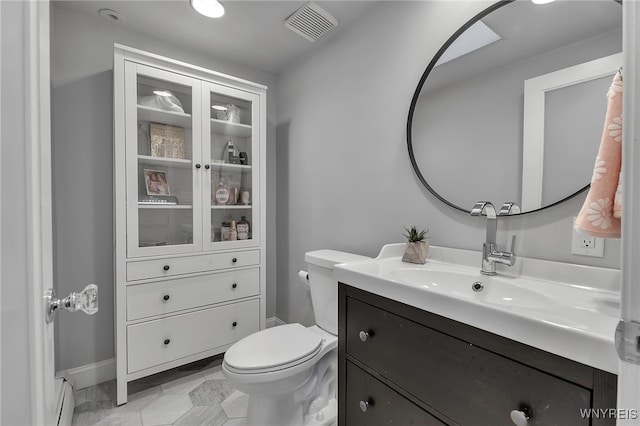 half bath with visible vents, toilet, vanity, and a baseboard radiator
