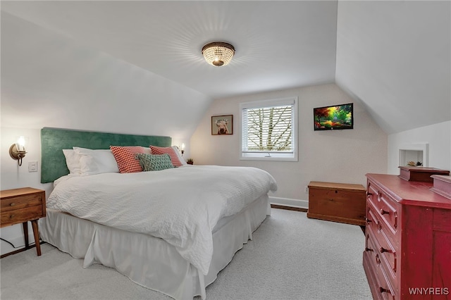 bedroom featuring lofted ceiling, light colored carpet, and baseboards