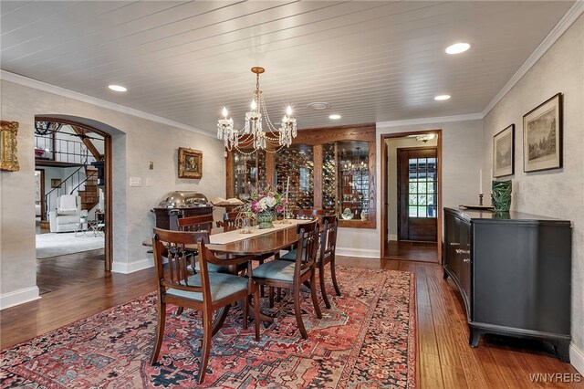 dining area featuring stairway, a chandelier, dark wood-type flooring, and arched walkways