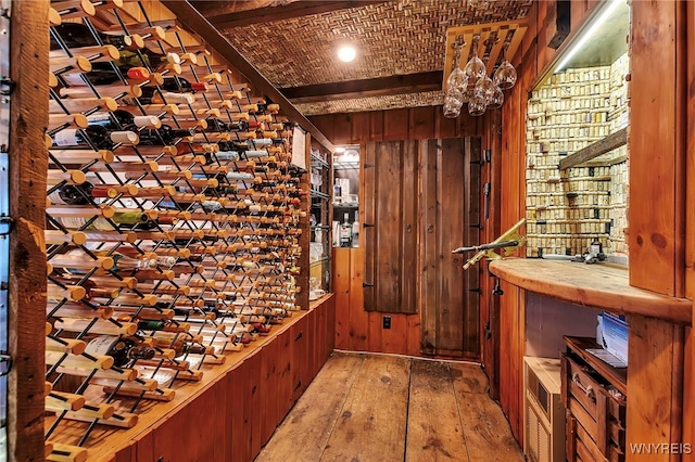 wine area featuring wood walls and hardwood / wood-style flooring