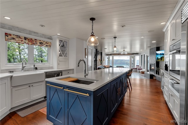kitchen featuring blue cabinetry, light countertops, and a sink