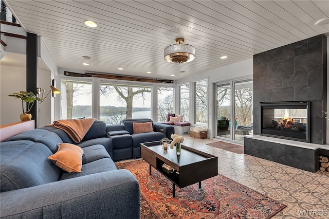 living room with recessed lighting and a tiled fireplace
