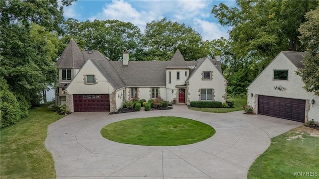 4482 Lower River Rd, Lewiston, NY 14092 - view of front facade featuring curved driveway, a chimney, a garage, and a front yard
