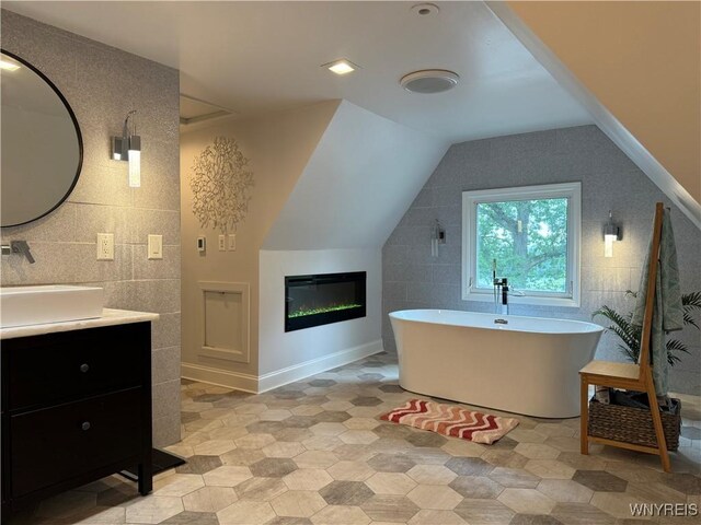 4482 Lower River Rd, Lewiston, NY 14092 - bathroom featuring vanity, tile walls, a freestanding tub, and vaulted ceiling