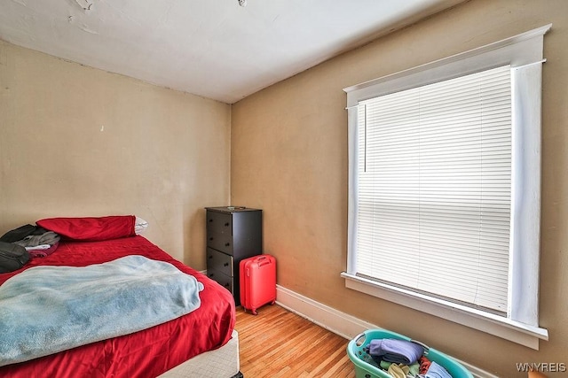 bedroom with baseboards and wood finished floors