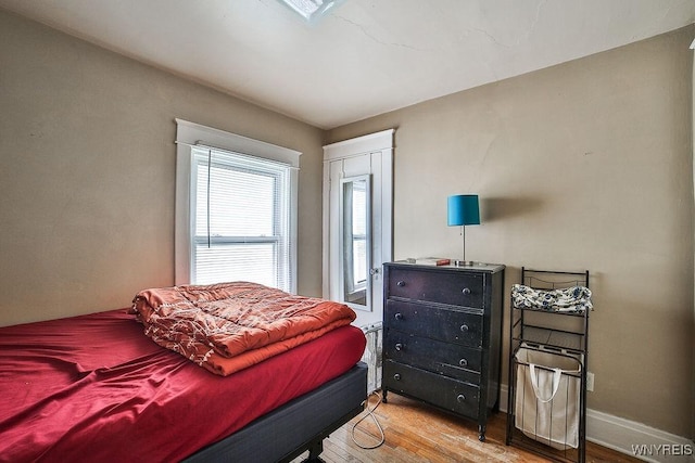 bedroom featuring wood finished floors and baseboards