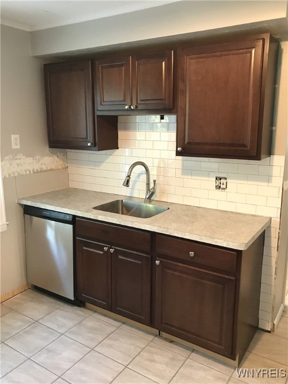 kitchen with tasteful backsplash, light countertops, stainless steel dishwasher, and a sink