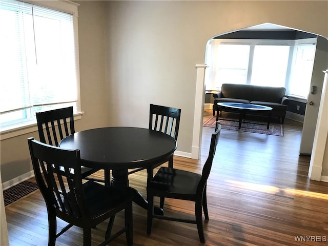 dining room featuring baseboards, visible vents, and wood finished floors