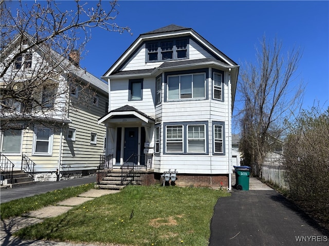 view of front of home featuring fence and a front lawn
