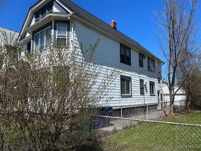view of home's exterior featuring a chimney, fence, central AC, and a yard