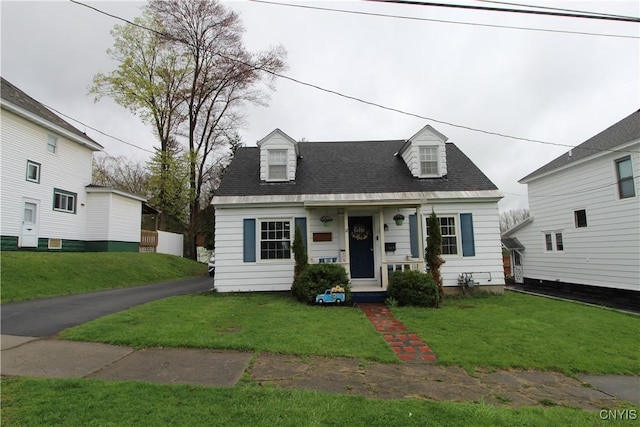 cape cod house with roof with shingles and a front lawn