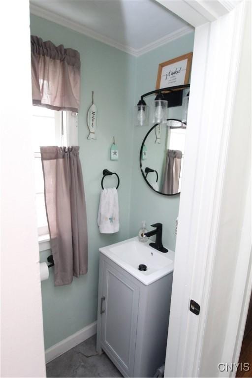 bathroom with crown molding, baseboards, and vanity