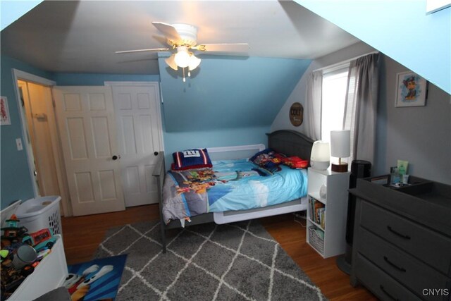 bedroom with ceiling fan, wood finished floors, and lofted ceiling
