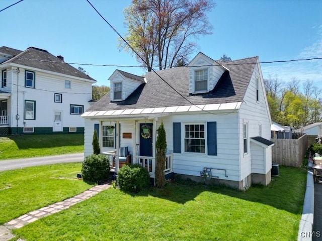 view of front of home with central AC, a front lawn, fence, and covered porch